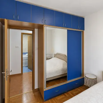 Bedroom with a built-in blue wardrobe and a view of the bathroom. - image 8