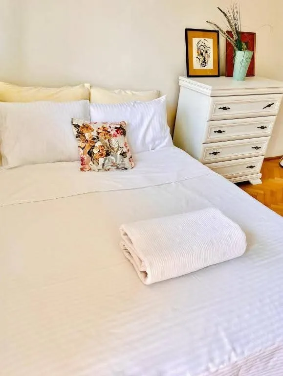 A furnished bedroom with a double bed and a white dresser.
