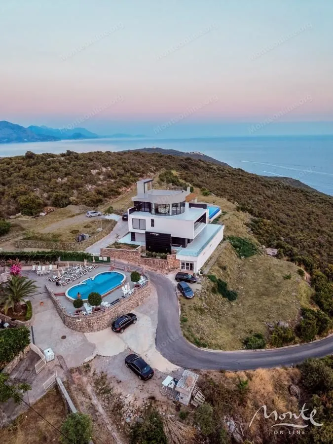 Aerial view of a modern villa with a swimming pool and sea view.