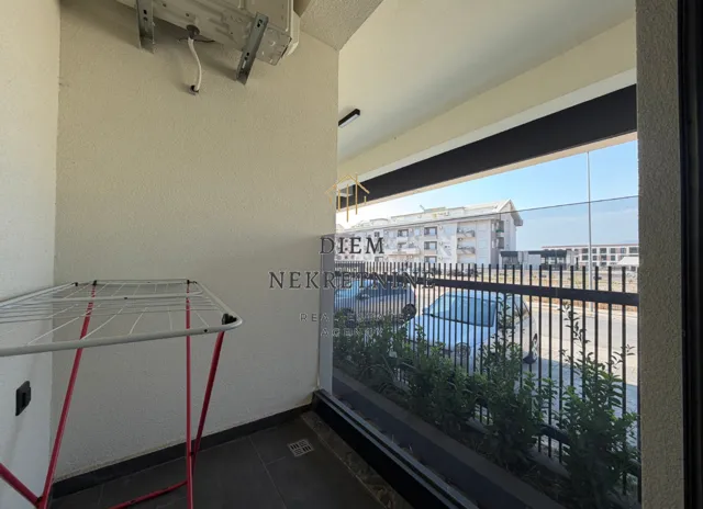 Small balcony with a clothes drying rack and street view.