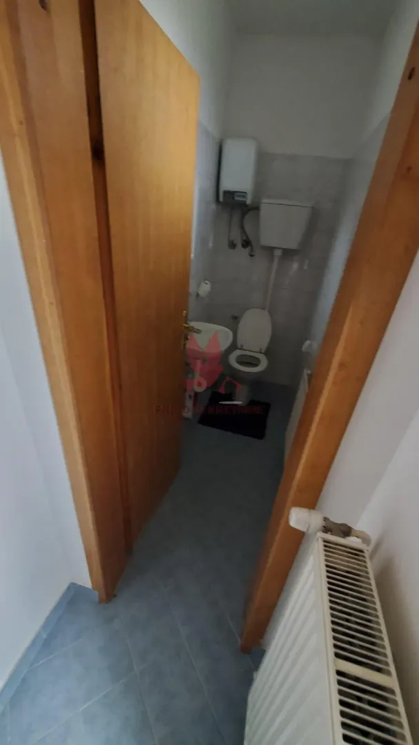 Pogled na kupatilo sa toaletom kroz otvorena vrata.