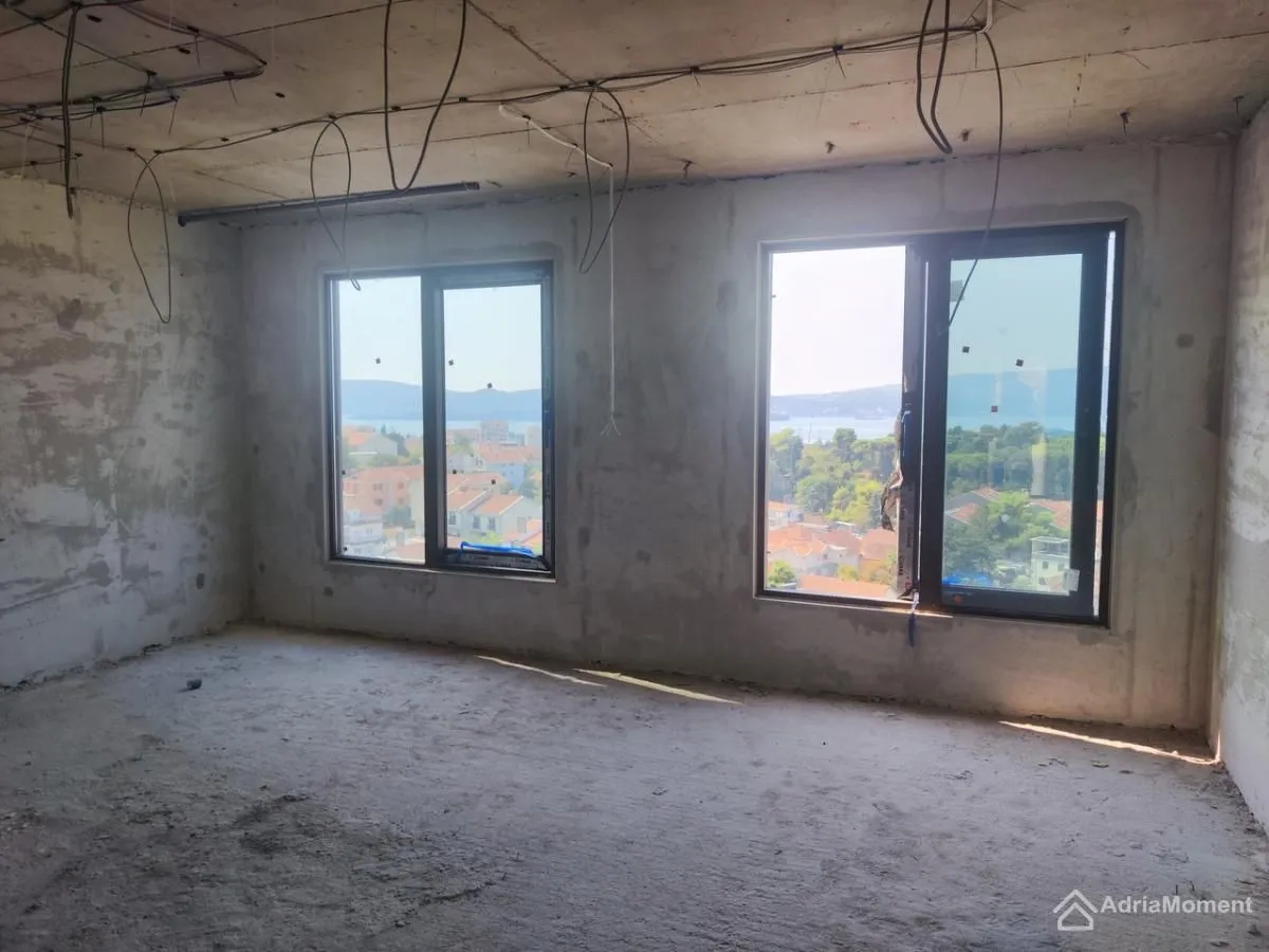 Neopremljena prostorija u izgradnji sa prozorima i pogledom na more.