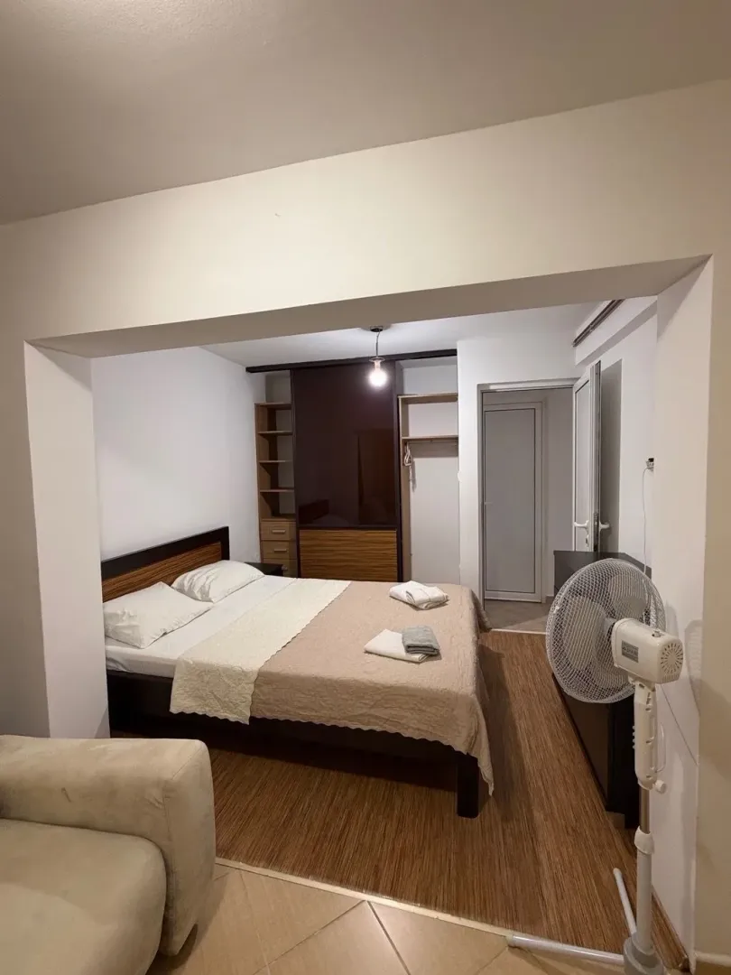 View from the living room into the bedroom with a double bed and wardrobe.