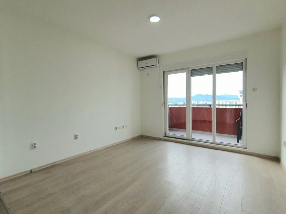 Empty room with light wooden flooring and access to a terrace.
