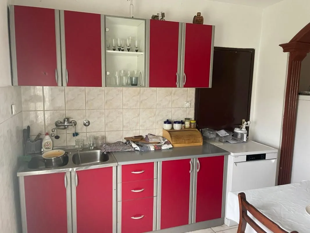 Kitchen with red cabinets, a sink, and a countertop.