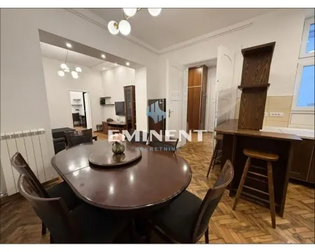 Trpezarija sa drvenim stolom i stolicama, povezana sa dnevnim boravkom. - image 3