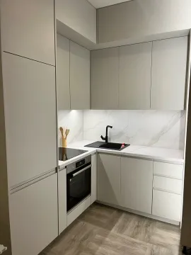 Moderna bijela kuhinja sa ugradnom rernom, pločom i crnom slavinom. - image 5