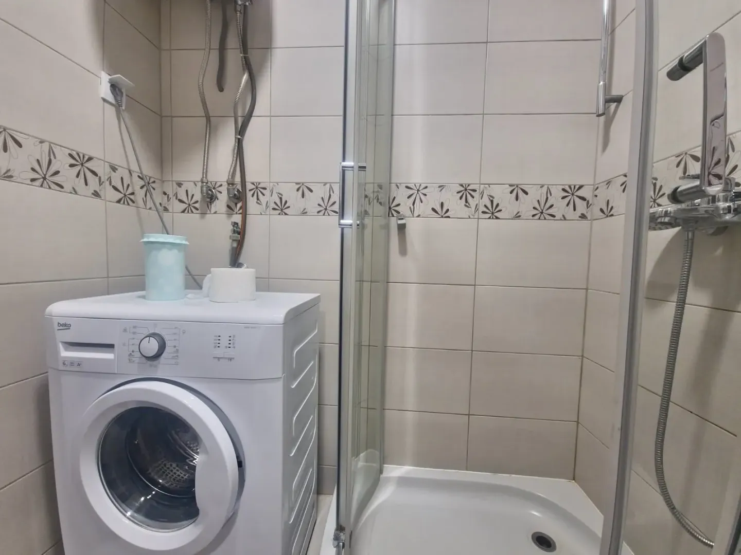 Bathroom with a shower cabin and a washing machine.