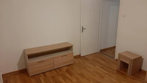 Prazna soba sa drvenim podom i komadom nameštaja. - image 13