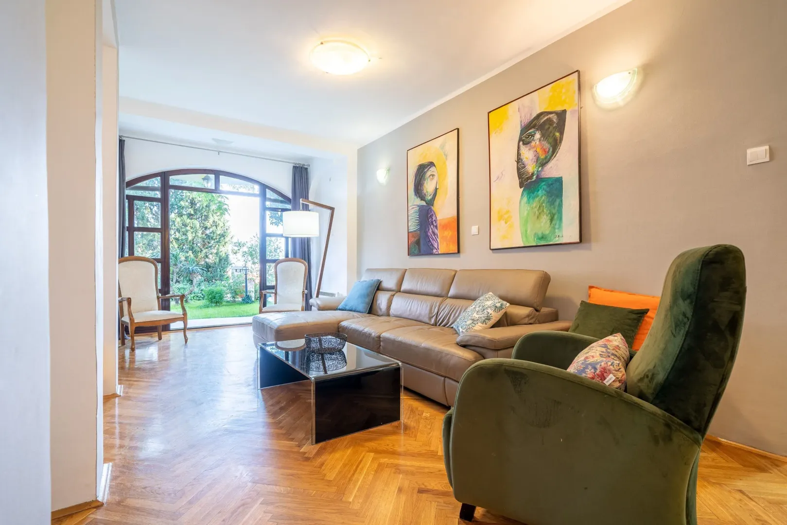 Spacious living room with sofa, parquet flooring, and a view of the courtyard.