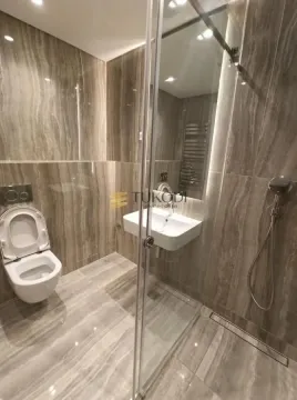 Modern tiled bathroom with a walk-in shower and a wall-hung toilet. - image 8