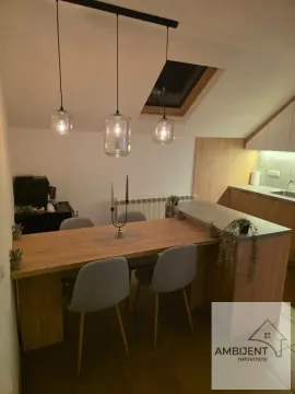 Modern kitchen with a dining table and chairs under a skylight. - image 4