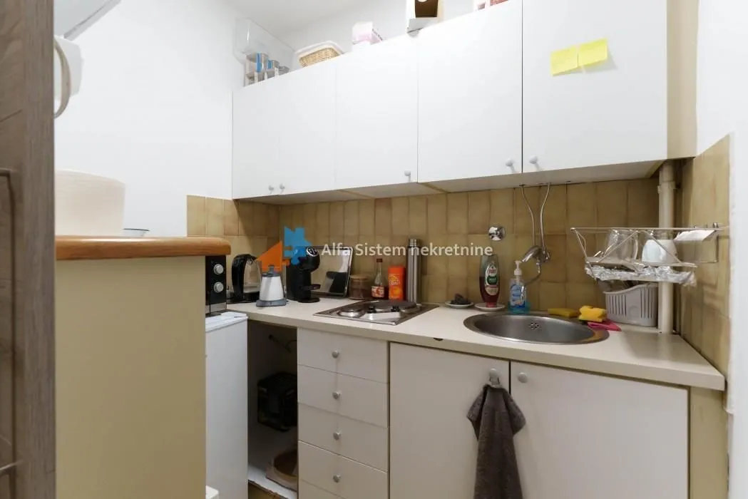 Small kitchen with white cabinets and a sink.
