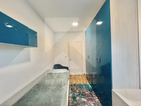 Small bedroom with a bed and blue built-in wardrobes. - image 6