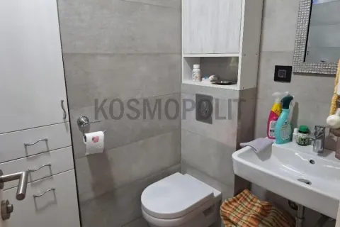Manje kupatilo sa WC šoljom, umivaonikom i ugrađenim elementima za odlaganje. - image 14