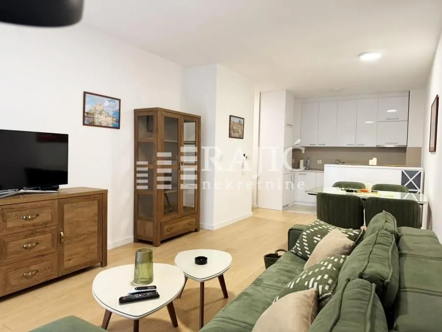 Living room with dining area and kitchen in light tones.