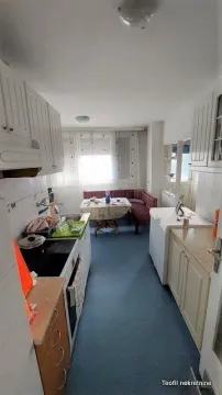 Small kitchen with an adjoining dining area and white kitchen cabinets. - image 6