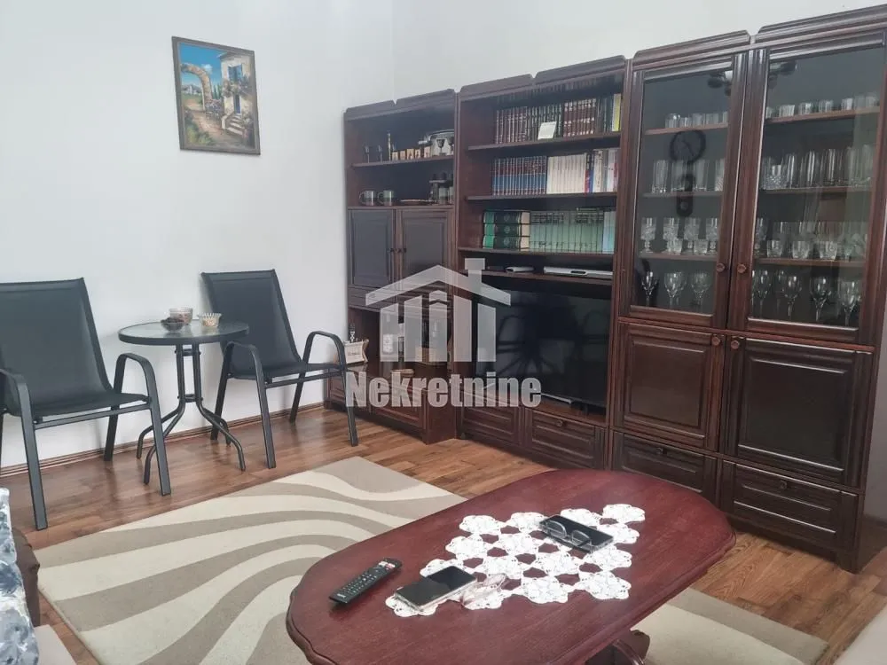 Dnevna soba sa drvenim nameštajem i stolom.