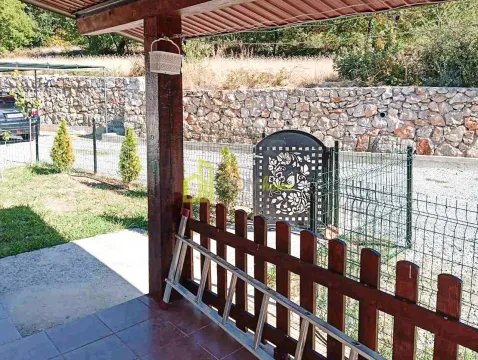 View from the covered terrace towards the yard with a fence and gate. - image 11