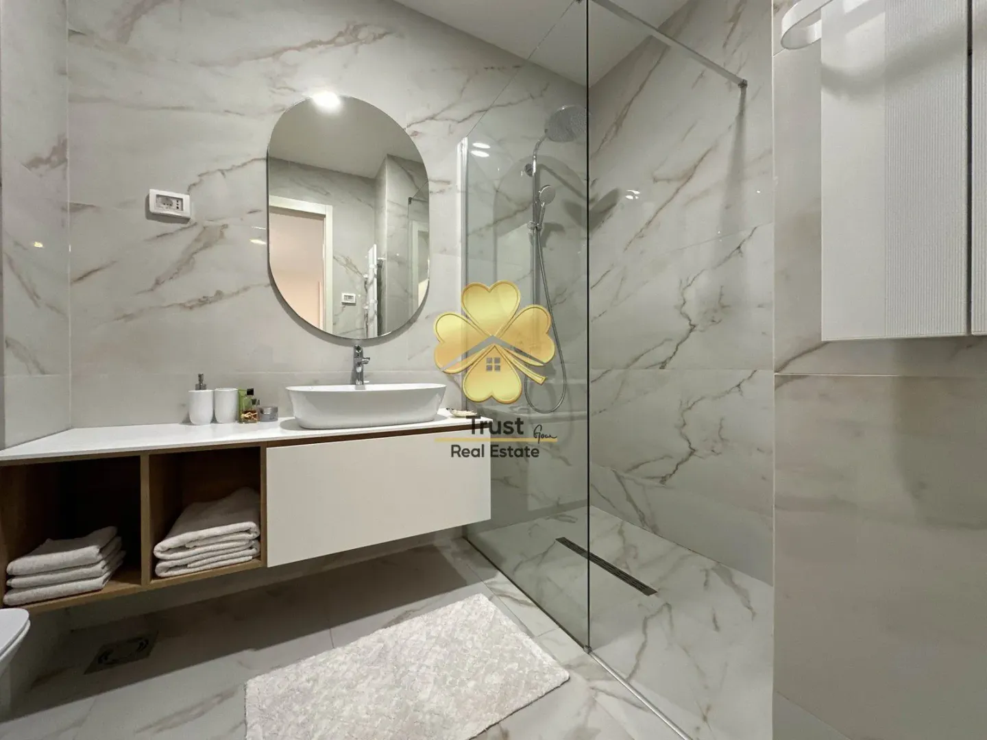 Modern bathroom with a sink, mirror, and walk-in shower.