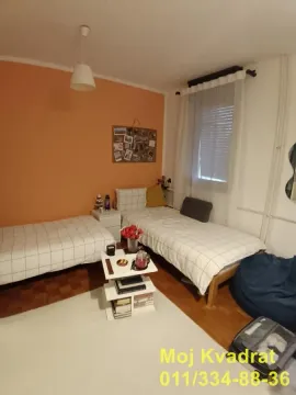 Spavaća soba sa dva singl kreveta i narandžastim zidom. - image 9