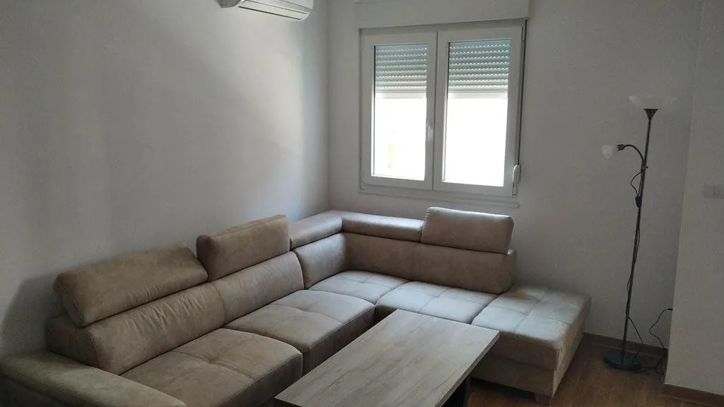 Living room with a sectional sofa, coffee table and a window.