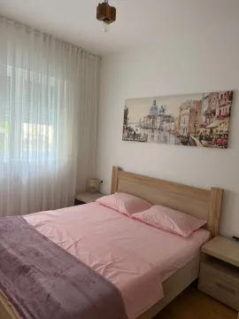 Spavaća soba sa bračnim krevetom, noćnim stočićima i velikim prozorom. - image 6