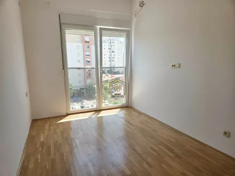 Prazna soba sa drvenim parketom i balkonskim vratima. - image 7