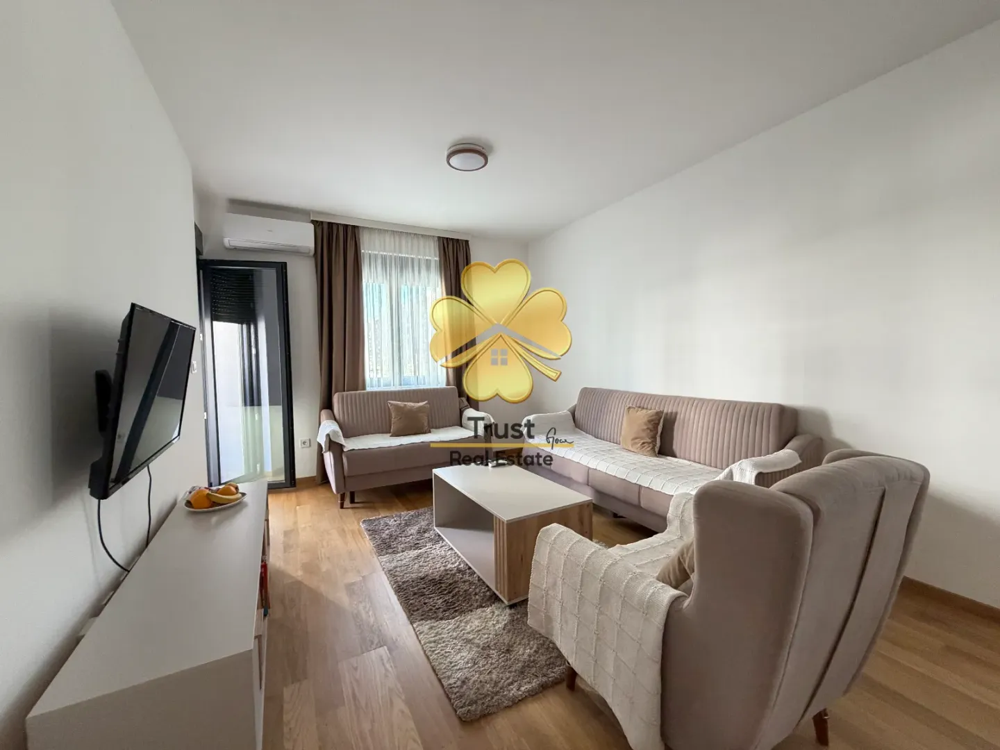 Living room with sofa set, coffee table, and TV.