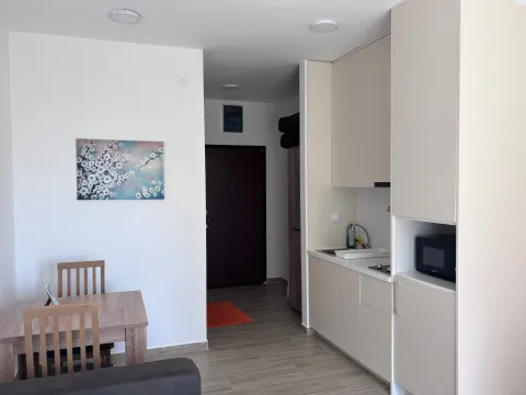 Manja kuhinja sa svijetlim elementima i trpezarijskim stolom u stanu. - image 7