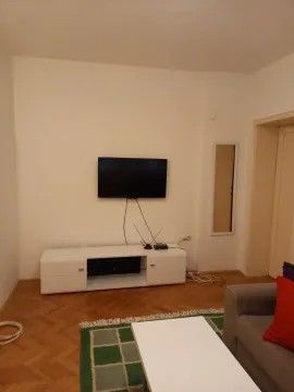 Simple living room featuring a TV stand and wall-mounted television. - image 8