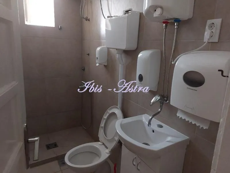 Smaller bathroom with a shower enclosure, toilet, and washbasin.