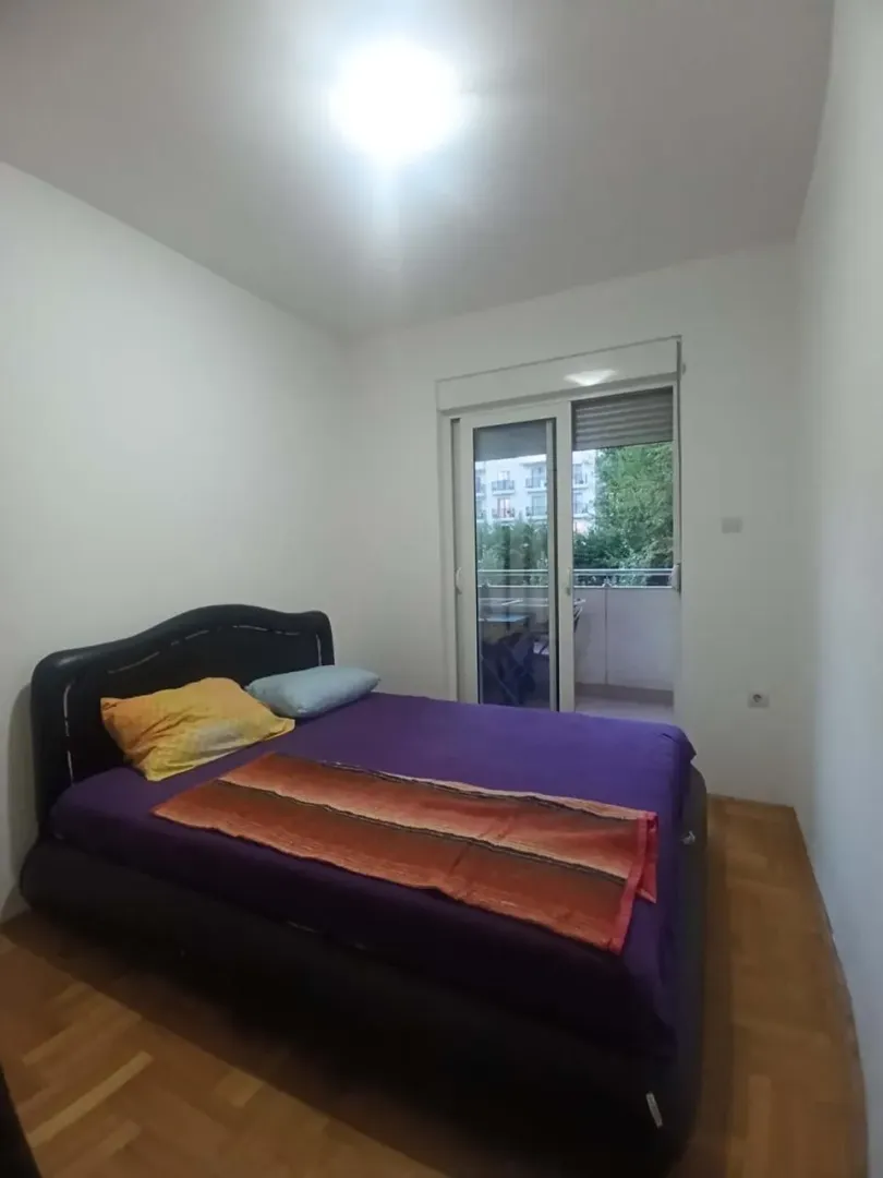 Spavaća soba sa bračnim krevetom i izlazom na terasu.