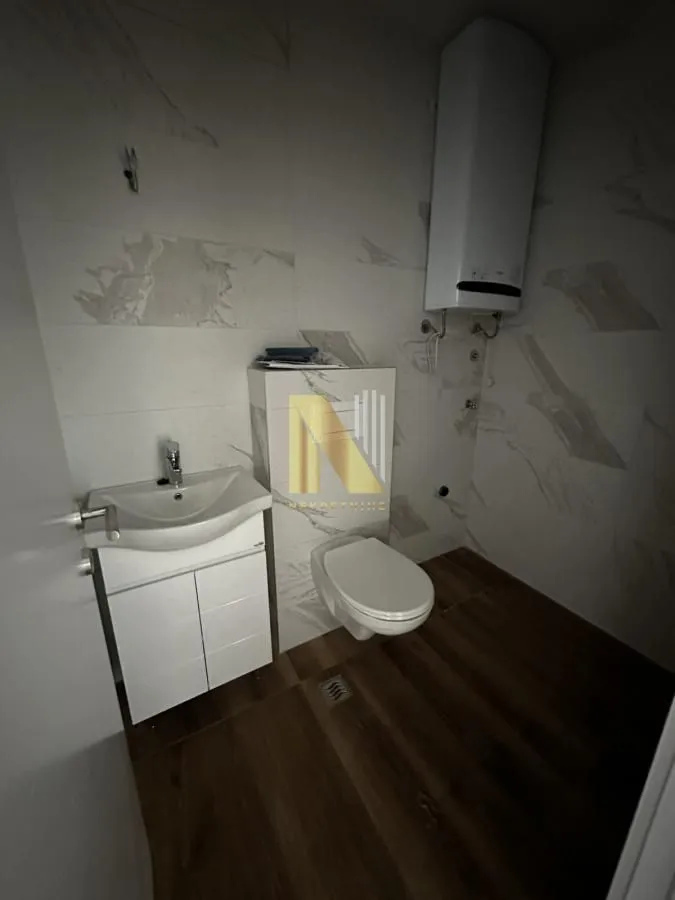 Moderno opremljeno kupatilo sa umivaonikom, WC šoljom i bojlerom.