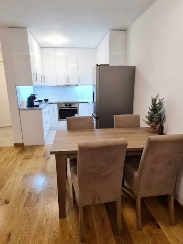 Dining area with a wooden table and chairs adjacent to the kitchen.