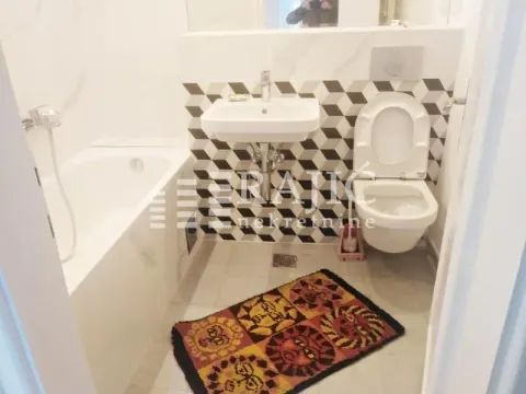 Modern bathroom with a bathtub, washbasin, and toilet. - image 19