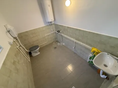 Small bathroom with ceramic tiles, washbasin, and toilet. - image 2