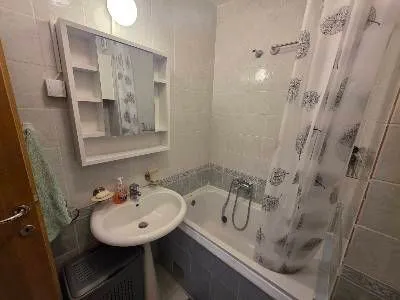 Small bathroom with a bathtub, washbasin, and mirrored cabinet. - image 10