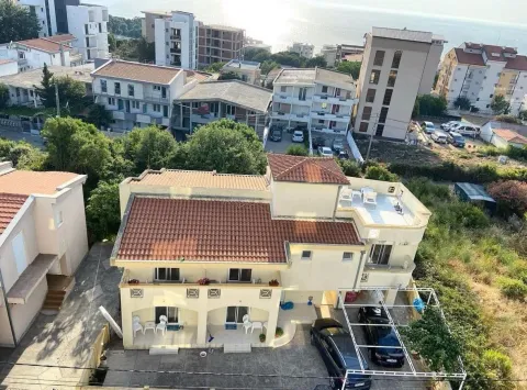 Pogled odozgo na trospratnu kuću sa terasama i parkingom blizu mora. - image 11