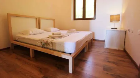 Spavaća soba sa bračnim krevetom, drvenim podom i lampom na noćnom stočiću. - image 22