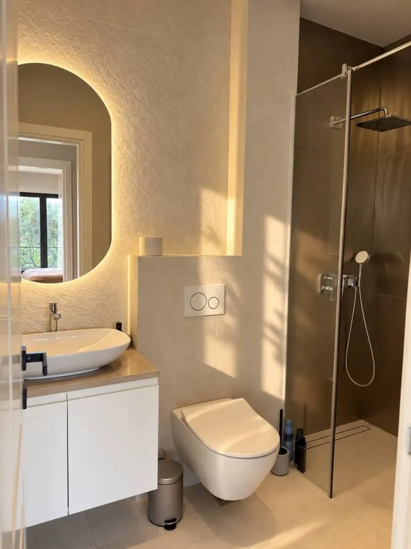Moderne opremljeno kupatilo sa tuš kabinom i umivaonikom.