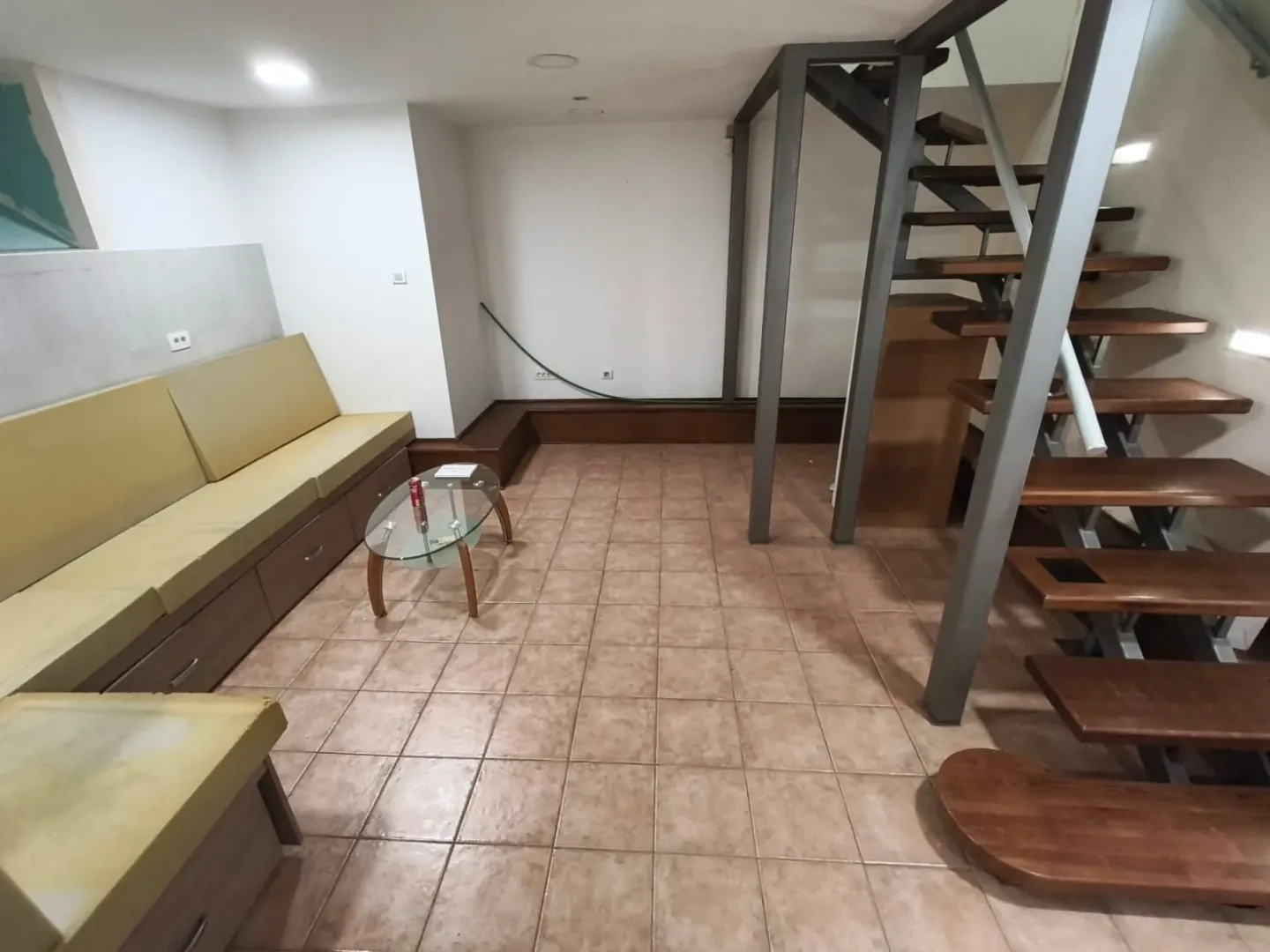 Living room with a sofa seating set and interior stairs.