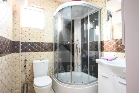 Bathroom equipped with a shower cabin, washbasin, and toilet. - image 13