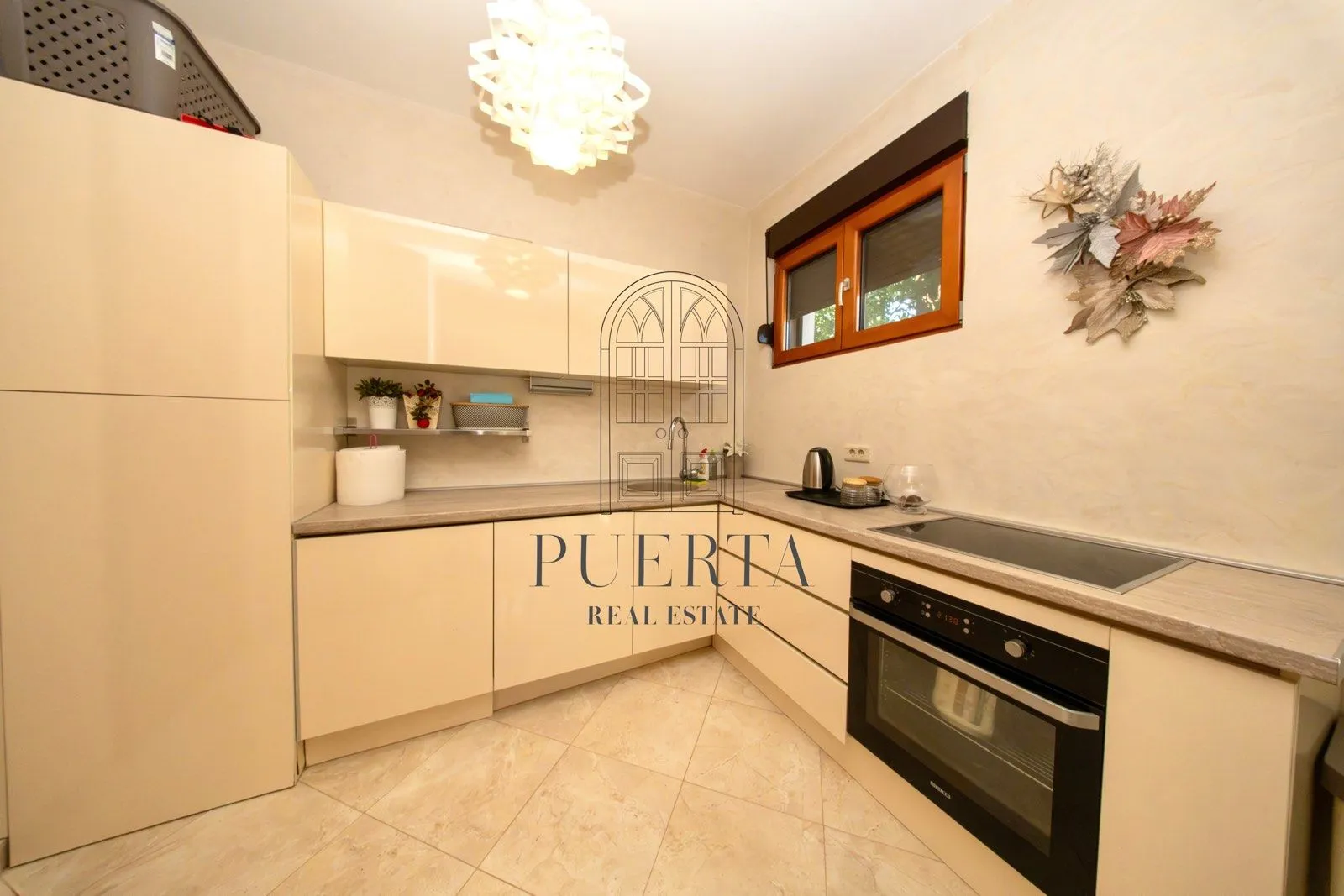 Small bright kitchen with beige cabinets and built-in appliances.