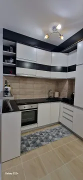 Modern kitchen with black and white elements and built-in appliances. - image 6