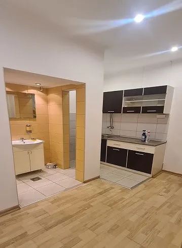 View of the kitchen with wooden flooring and an adjacent bathroom area.