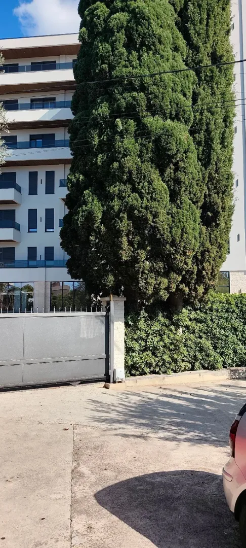 View of the exterior of a residential building with a yard and a gate.