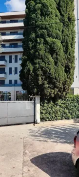 View of the exterior of a residential building with a yard and a gate. - image 14