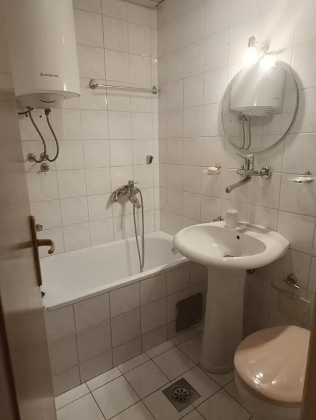 Manje kupatilo sa kadom, umivaonikom, wc šoljom i bojlerom.