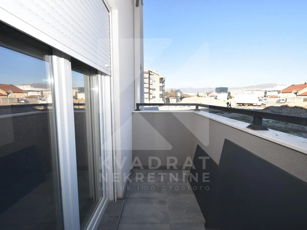 View from the balcony towards surrounding buildings and a construction site.
